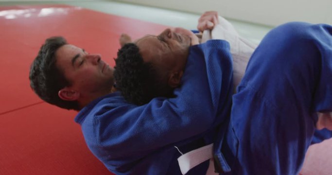 Judoka strangling his opponent on the judo mat