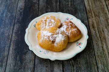 Mandazi is a slightly sweet East African Street Food; spicy, airy yeast doughnut dough made with coconut milk, flavored with cardamom and grated fresh coconut.