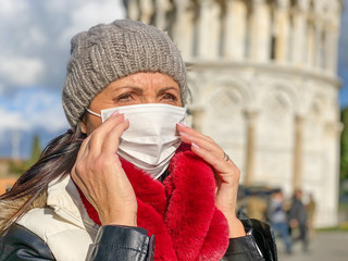 Coronavirus Covid-19 is spreading across Italy and Europe. Woman visiting Pisa wearing protective face mask to avoid contagion outbreak