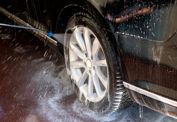 High-pressure washing of a car wing mirror. Self-service car washes. Remove road salt from car rims...