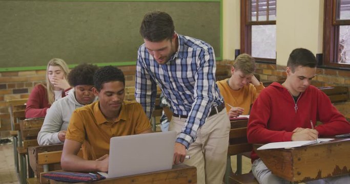 Teacher helping a teenager in high school class