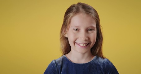 Portrait of happy caucasian little girl smiling, looking at camera. Redhead female child with cheerful emotions and feelings. Copy space