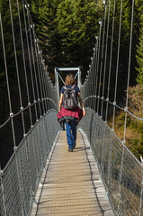 woman crossing a suspended bridge in Engadin, Switzerland