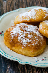 Mandazi is a slightly sweet East African Street Food; spicy, airy yeast doughnut dough made with coconut milk, flavored with cardamom and grated fresh coconut.