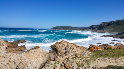 Fototapeta na wymiar An amazing rocky beach next to a body of water in south africa Plettenberg Bay