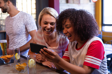 Friends laughing while looking at the phone