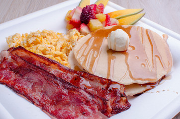 Pancakes, with scrambled egg, bacon and fruit