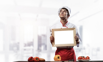 Young male chef standing near cooking table