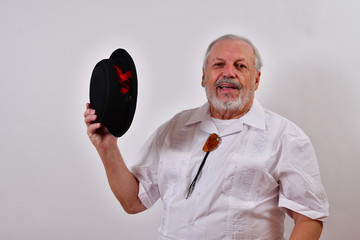 Happy old man smiling and waving his porkpie hat.Elderly gentleman is giving a friendly greeting.Senior man happy, waving his hat and smiling.