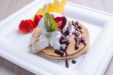 Egg pancakes, ice cream, chopped fruits and chocolate sauce