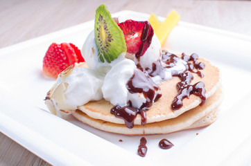 Egg pancakes, ice cream, chopped fruits and chocolate sauce