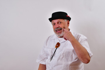 Cute old man pressing his cheek with one finger to show his dimple..Elderly gentleman showing his dimple.Senior man smiling and showing his dimple.