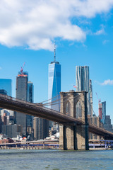 Fototapeta na wymiar The Brooklyn Bridge with an American Flag over the East River with the Lower Manhattan New York City Skyline