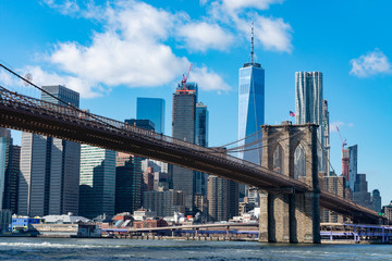 Fototapeta na wymiar The Brooklyn Bridge with an American Flag over the East River with the Lower Manhattan New York City Skyline