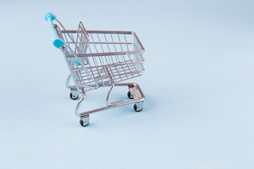 on a blue background an empty shopping cart on wheels