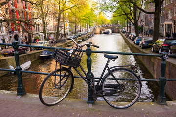 Naklejka premium Miasto Amsterdam w Holandii z rowerami obok kanału