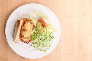 Vegan sandwich for breakfast, healthy & delicious food for plant based, vegan and vegetarian diet. Ingredients are toasted bread, vegan cheese, fried tofu, tomato, iceberg lettuce and kaiware sprouts.