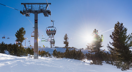 Snowy ski slopes and chair ski lifts station in  mountain ski resort.