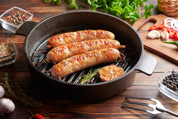 Homemade sausages fried in a pan, lie on a wooden table