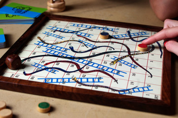 kid playing vintage snakes and ladders board game