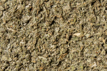 dried artichoke leaves or in latin Cynarae folium herb background. medicinal healing herbs. herbal...