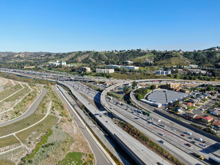 Aerial view of highway with traffic surrounded by houses in Diamond Bar City. Intersection city transport road with vehicle movement. Eastern Los Angeles, California, USA.