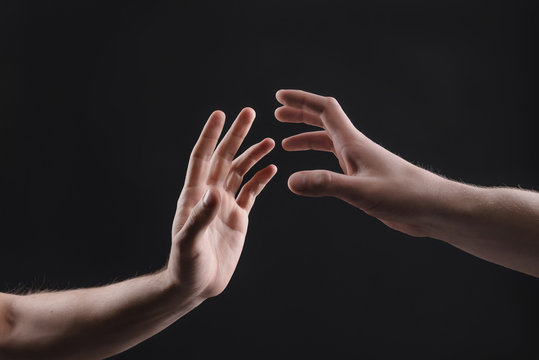 touch of 2 x male hands on a gray background