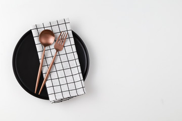 Empty plate with spoon, fork and table napkin on white background. Meal preparation concept. Top view