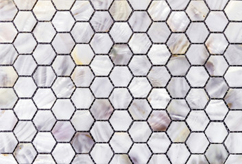 Mother of pearl mosaic tiles in the shape of honeycombs.