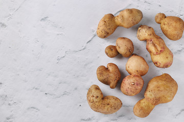 Ugly organic potatoes on marble background, Concept organic vegetables, Copy space