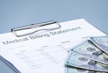 top view picture of medical billing statement,  banknotes on the gray background