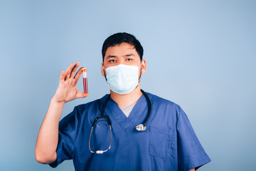 The doctor holding in his hands a test tube with blood, infected blood, blood for analysis