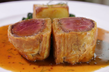 Close up of Beef Wellington with Spinach and fried potatoes