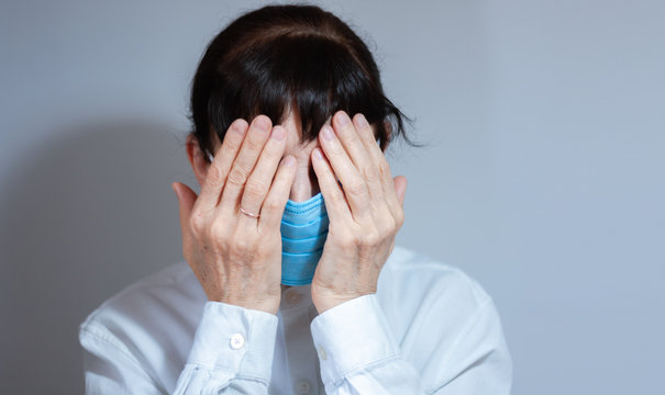 Coronavirus quarantine and Air pollution pm2.5 concept. Sick sad depressed, thoughtful old woman wearing respirator mask for protect. Wuhan, China epidemic virus symptoms background.