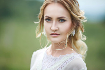 Naklejka premium the bride walks in the field against the backdrop of the mountain