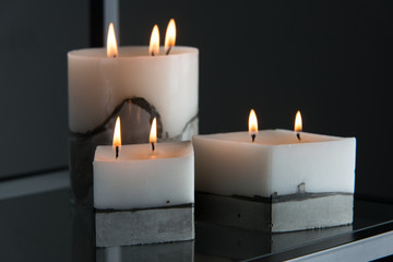 white candle on a concrete base