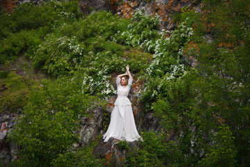 Obraz na płótnie Canvas the bride walks in the field against the backdrop of the mountain
