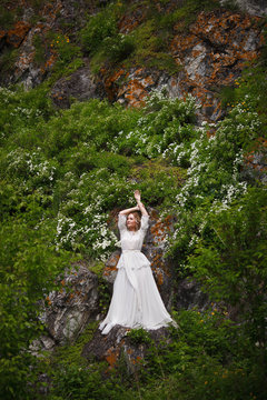 the bride walks in the field against the backdrop of the mountain