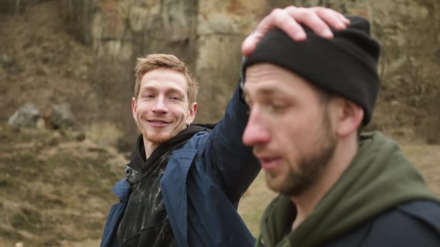 Two Young Guys Walking On The Road In Nature. They Joke And Laugh.