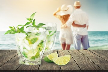 Cocktails and a happy couple walking on beach at the seaside