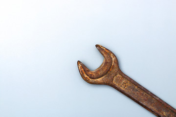 old rusty spanner on clean grey background with copy space