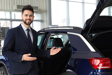 Fototapeta na wymiar Young salesman near new car in dealership