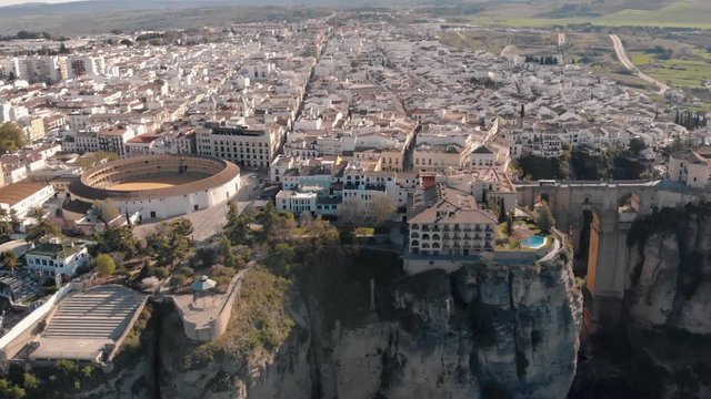 Aerial view of an ancient Spanish city Ronda in Andalucia. Drone flying over the famous bridge Puente Nuevo connecting the two parts of the Old Town, the Plaza de Toros (Bulls square) .