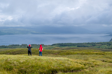 Tourists taking pictures from Island of Mull highest viewpoint. Nature of Scotland.