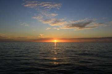 Sun setting over the large body of water