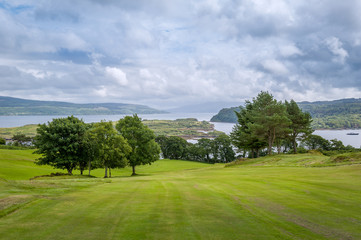 Fototapeta na wymiar Tobermory golf field view sea view. Beautiful nature of Scotland landscapes.