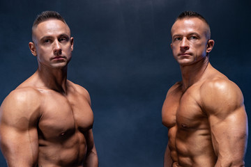 Two Muscular man isolated on the black background. Strong male naked torso abs
