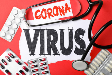 Flat lay composition with phrase CORONA VIRUS and medicines on red background