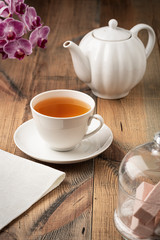 Fototapeta na wymiar Tea in a white ceramic cup and teapot on the table.