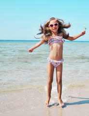 Summertime. Little girl has fun on the beach. Summer concept.